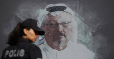 A Turkish police officer walks past a picture of slain Saudi journalist Jamal Khashoggi prior to a ceremony, near the Saudi Arabia consulate in Istanbul, marking the one-year anniversary of his death, Oct. 2, 2019. (AP Photo)