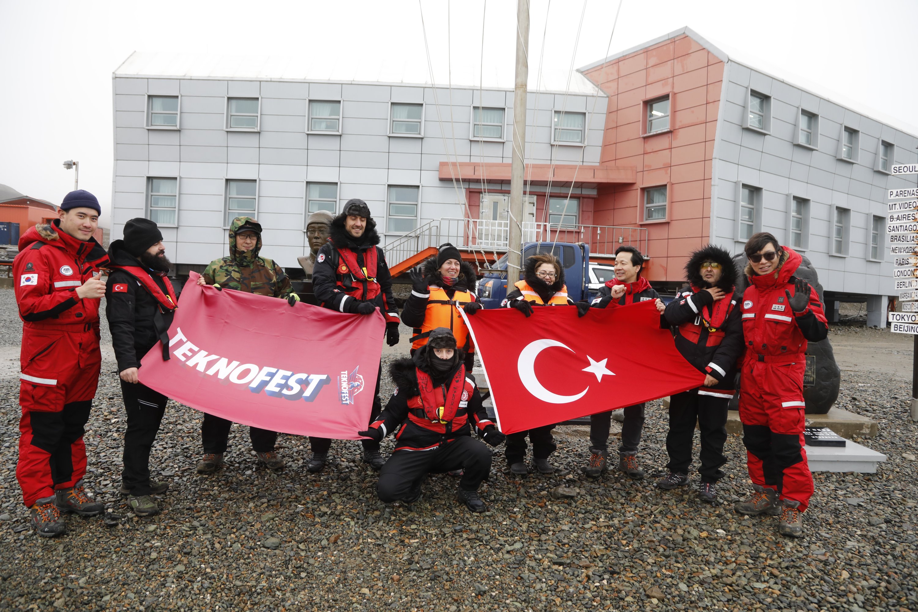 The team poses with a Turkish flag and a TeknoFest banner at the South Korean base. (Photos by Hayrettin Bektaş)