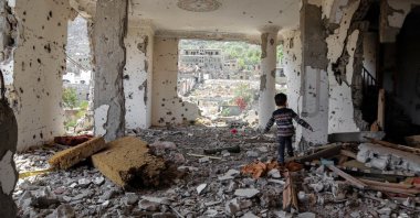 A child walks among the rubble of a building that was destroyed in an airstrike in Taez, Yemen, March 18, 2018. (AFP Photo)
