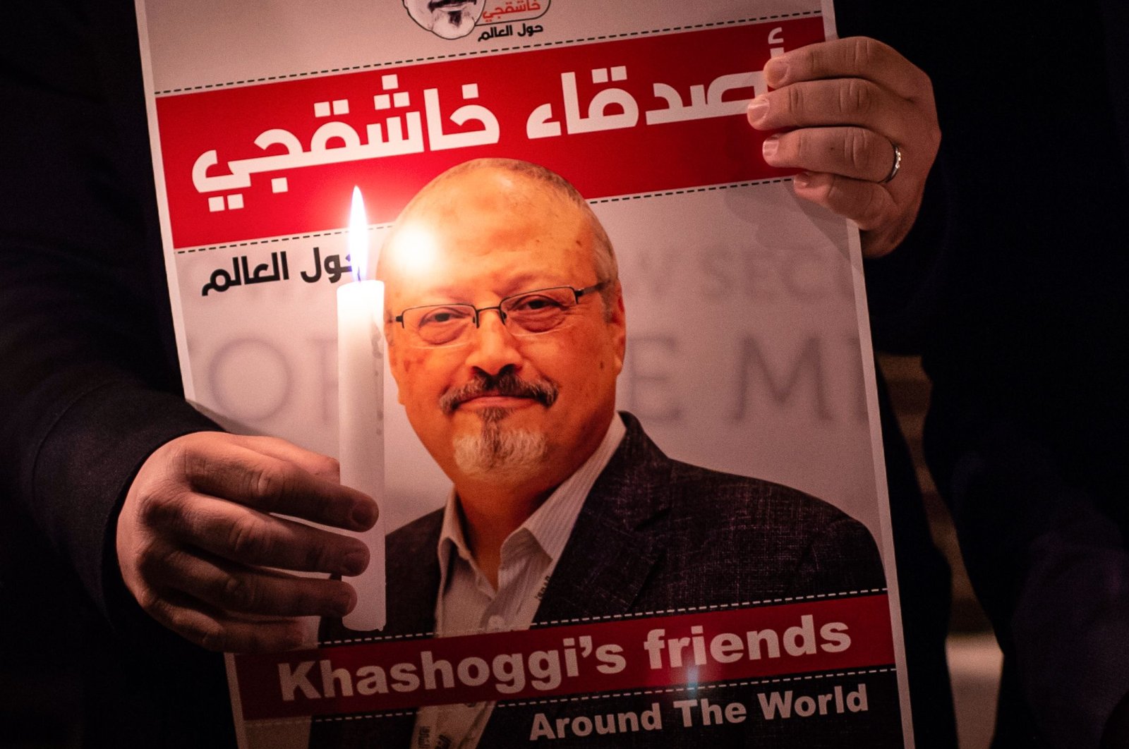 A demonstrator holds a poster picturing Saudi journalist Jamal Khashoggi and a lighted candle during a gathering outside Saudi Arabia's consulate in Istanbul, Turkey, Oct. 25, 2018. (AFP Photo)