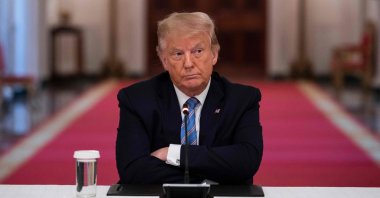 U.S. President Donald Trump sits with his arms crossed during a roundtable discussion on the Safe Reopening of America’s Schools during the coronavirus pandemic, in the East Room of the White House in Washington, D.C. on July 7, 2020. (AFP Photo)