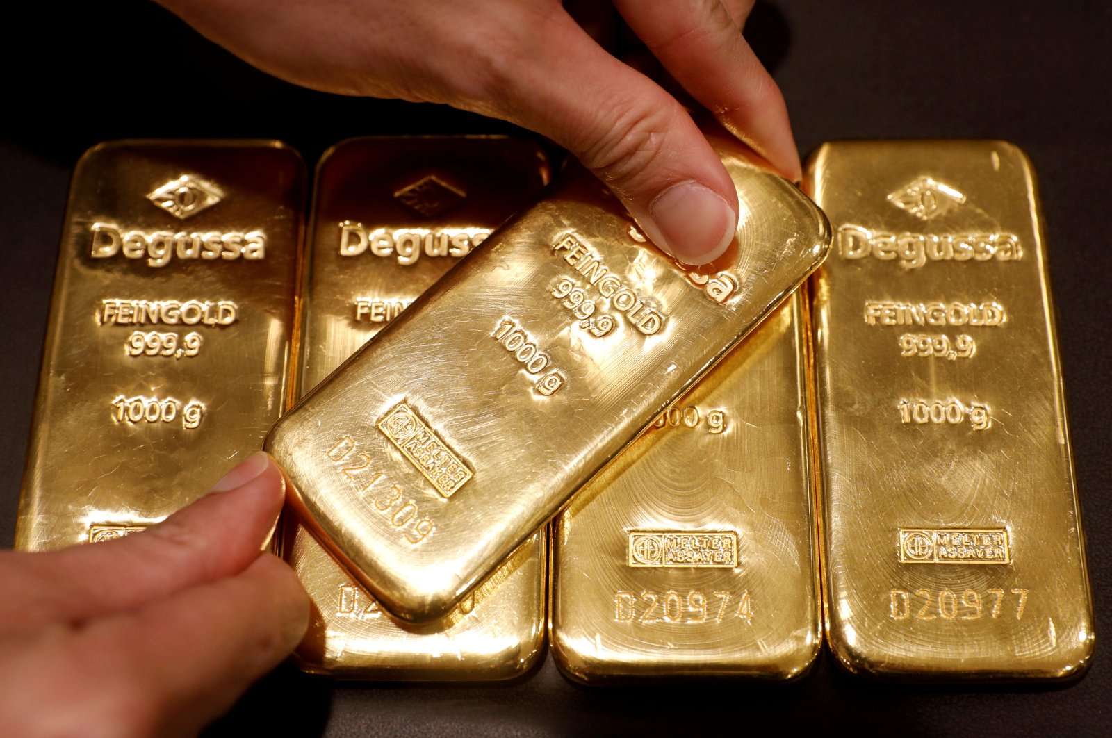 In this June 16, 2017, file photo, an employee shows gold bullions at Degussa shop in Singapore. (Reuters Photo)