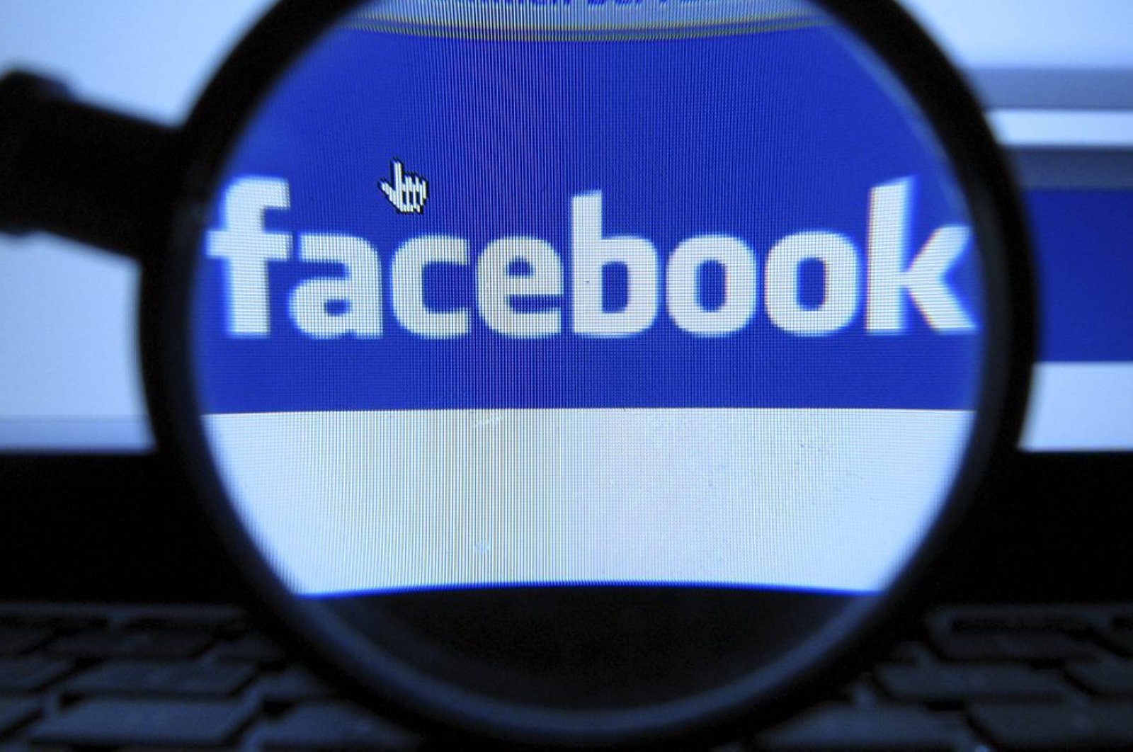 A magnifying glass is posed over a monitor displaying a Facebook page in Munich, Oct. 10, 2011. (AP Photo)