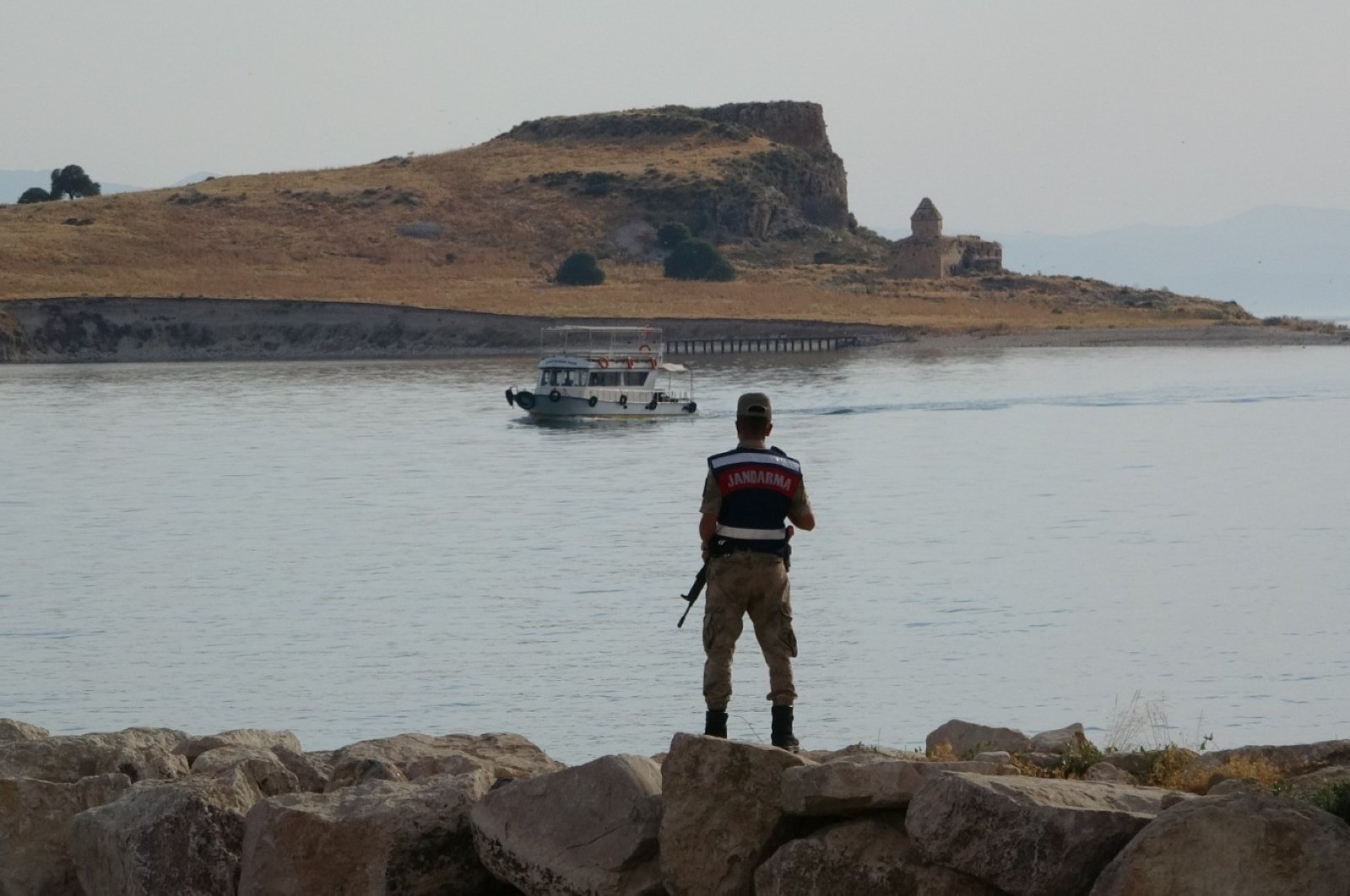 A Turkish gendarmerie soldier watches as the sank migrant boat is being taken out from the underwater in Lake Van, July 8, 2020. (IHA)