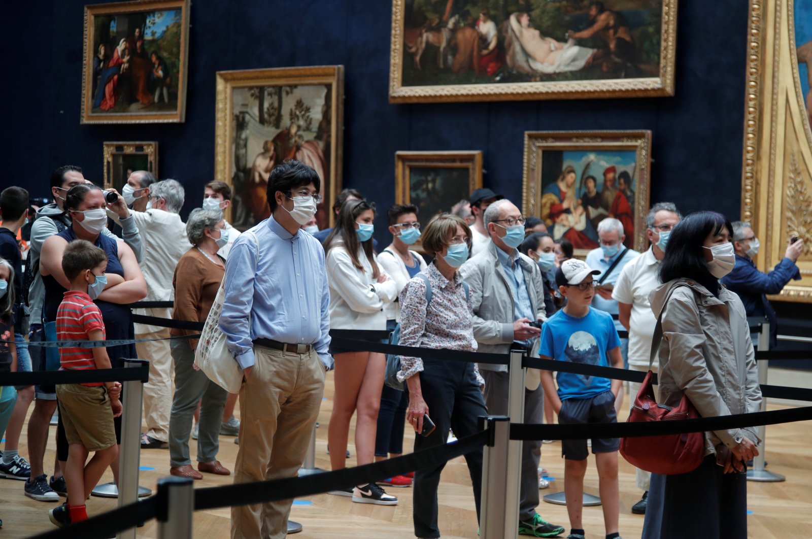 Visitors, wearing protective face masks, queue to see the painting "Mona Lisa" (La Joconde) by Leonardo Da Vinci at the Louvre museum, Paris, July 6, 2020. (REUTERS Photo)