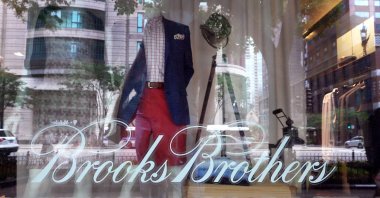 The Brooks Brothers logo is painted on the window of a store in closed along the Magnificent Mile in Chicago, Illinois, July 8, 2020. (AFP Photo)