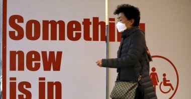 A tourist from South Korea wears a protective mask while waiting for a flight back to South Korea at the Ben Gurion airport near Tel Aviv, Israel, Feb. 24, 2020. (AP Photo)