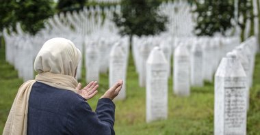 A woman prays at the memorial cemetery in Potocari, near Srebrenica, Bosnia-Herzegovina, July 7, 2020. (AP Photo)