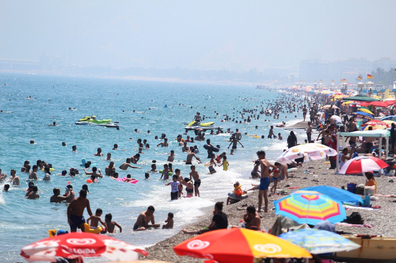 People are seen on Konyaaltı beach, amid the COVID-19 outbreak, in the southern resort city of Antalya, Turkey, July 5, 2020. (IHA Photo)