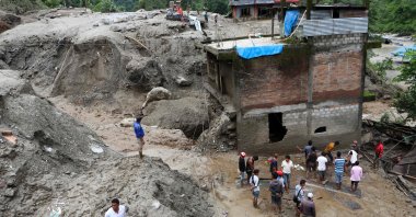 Residents and rescue workers inspect the area outside a house damaged by a landslide and the swell of the Thado-Koshi river due to heavy rains in Jambu village of Sindhupalchok district, some 80 kilometers northeast of Kathmandu, Nepal, July 9, 2020. (AFP Photo)