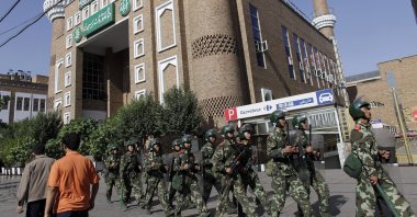 Ethnic Uighurs walk as Chinese army troops patrol outside the main mosque in Urumqi in China's Xinjiang Autonomous Region, July 10, 2009. (Reuters Photo)