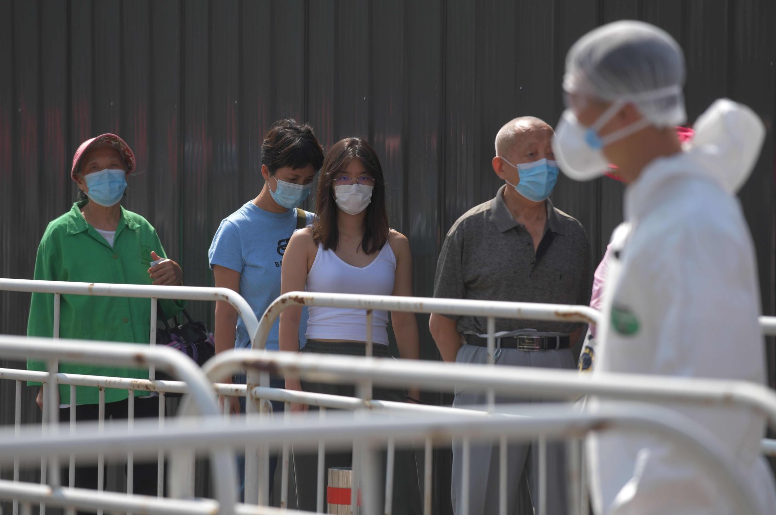 In this file photo people wait in line to undergo COVID-19 coronavirus swab tests at a testing station, Beijing, June 30, 2020. (AFP Photo)