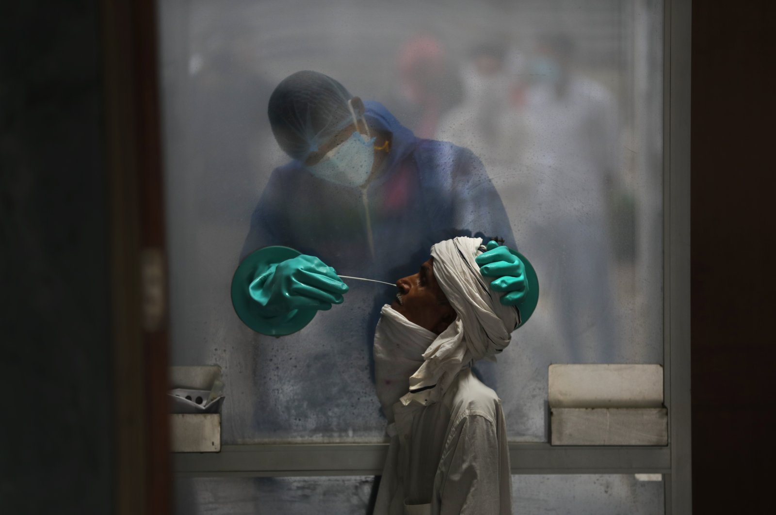 A health worker collects samples for a COVID-19 test at a hospital in New Delhi, India, July 6, 2020. (AP Photo)