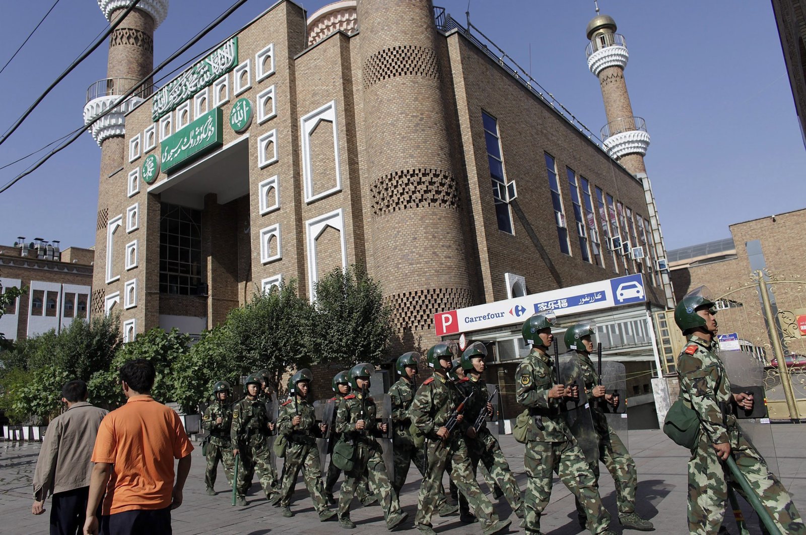 Ethnic Uighurs walk as Chinese army troops patrol outside the main mosque in Urumqi in China's Xinjiang Autonomous Region, July 10, 2009. (Reuters Photo)