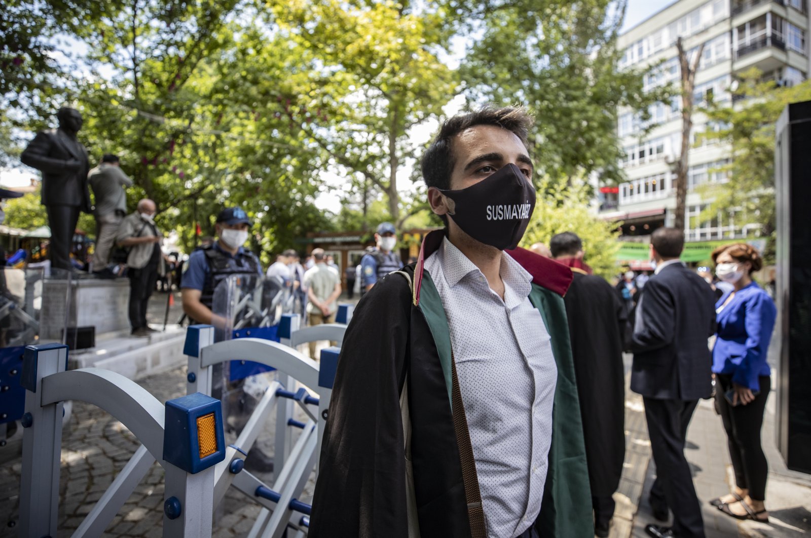 A lawyer wearing a face mask with the phrase “We will not be silenced” on it stands in protest against the controversial bar regulation in Ankara’s Kuğulu Park, Turkey, July 6, 2020. (AA Photo)