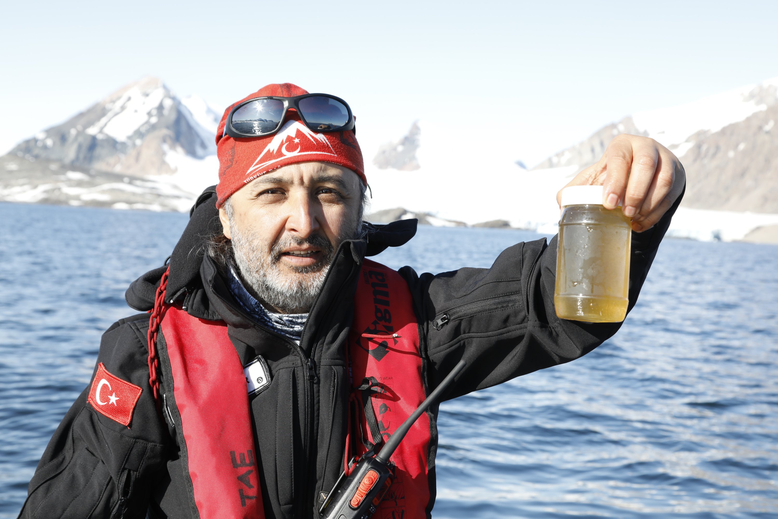 Expedition leader Ersan Başar collects samples from Antarctic water. (Photo by Hayrettin Bektaş)