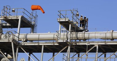 Workers stand on a platform at a Saudi Aramco oil separator processing facility in Abqaiq, near Dammam in the kingdom's Eastern Province, Sept. 20, 2019. (AP Photo)