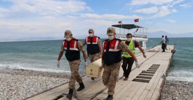 Members of Turkish security forces carry a recently recovered body of a migrant amid sinking of a migrant boat in Lake Van, July 13, 2020. (AA)