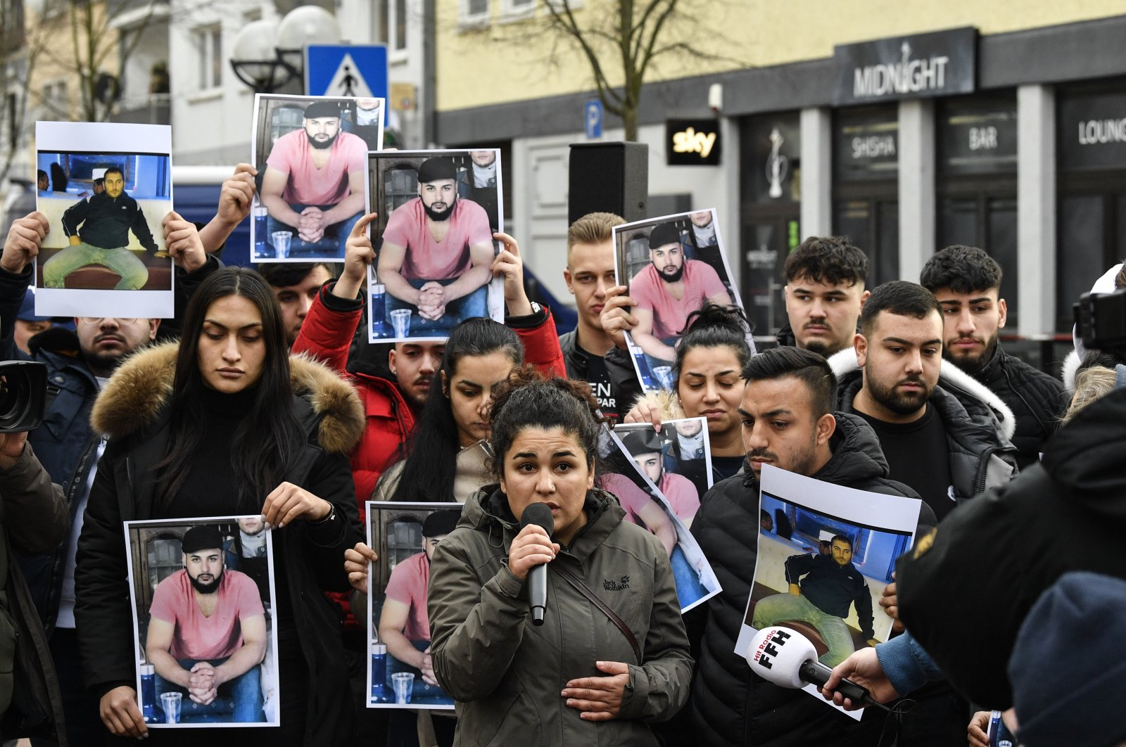 Friends and relatives hold up photos of victims of a shooting in Hanau, Germany, Feb. 21, 2020. (AP Photo)