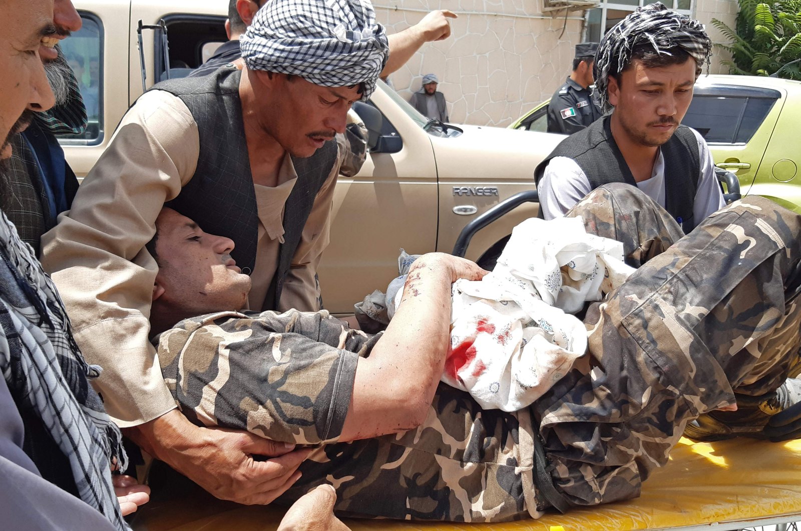 A wounded National Directorate of Security (NDS) personnel is brought on a stretcher to a hospital after a car bomb exploded in Aybak, northern Samangan province, Afghanistan, July 13, 2020. (AFP Photo)