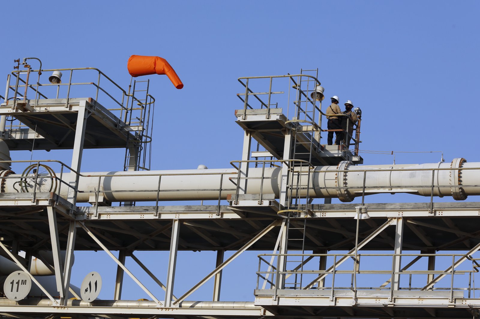 Workers stand on a platform at a Saudi Aramco oil separator processing facility in Abqaiq, near Dammam in the kingdom's Eastern Province, Sept. 20, 2019. (AP Photo)