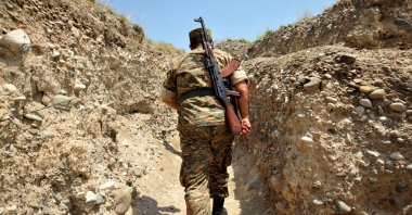 In this file photograph, an Armenian soldier of the self-proclaimed republic of Nagorno-Karabakh walks in a trench at the frontline on the border with Azerbaijan near the town of Martakert, July 11, 2012. (AFP Photo)