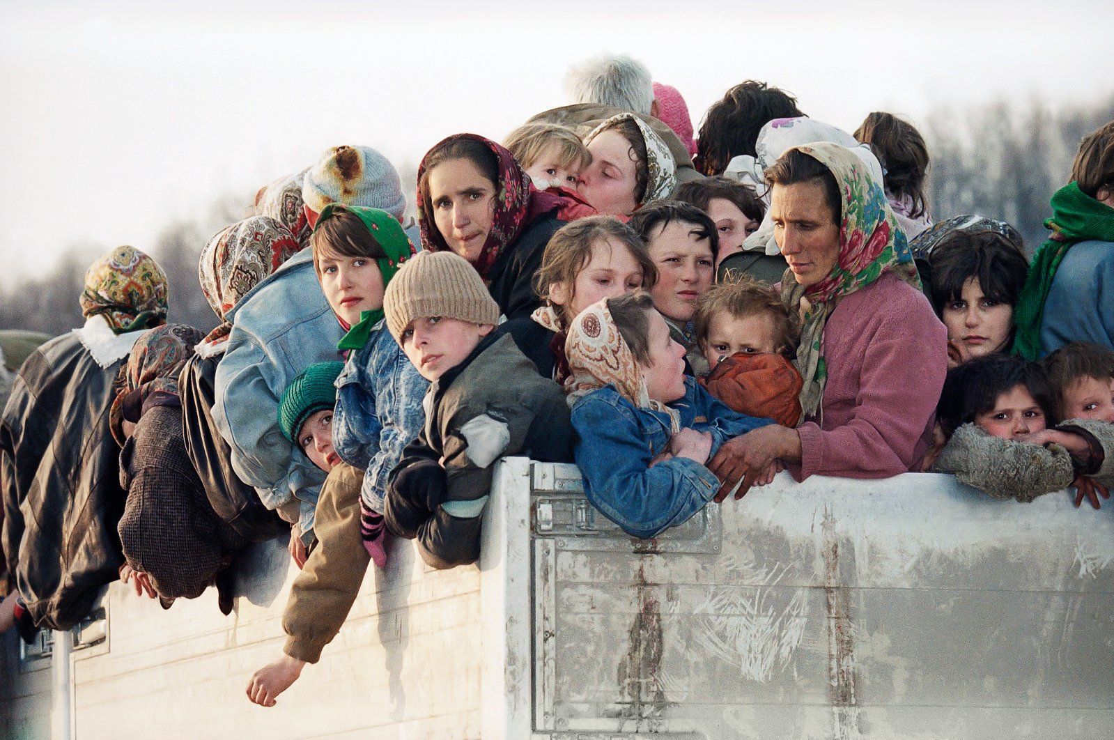 Evacuees from the besieged Muslim enclave of Srebrenica, packed on a truck en route to Bosnian city of Tuzla, pass through the Tojsici village, March 29, 1993. (AP Photo)