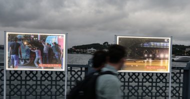 Pedestrians walk past a photo exhibition organized on Galata Bridge displaying the incidents and the people's resistance to the July 15 coup attempt by the Gülenist Terror Group (FETÖ), Istanbul, Turkey, July 13, 2020. (AA Photo)