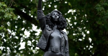 A new black resin and steel statue entitled "A Surge of Power (Jen Reid) 2020" by artist Marc Quinn stands after it was put up on the empty plinth of the toppled statue of 17th-century slave trader Edward Colston, which was pulled down during a Black Lives Matter protest, Bristol, England, July 15, 2020. (AP Photo)
