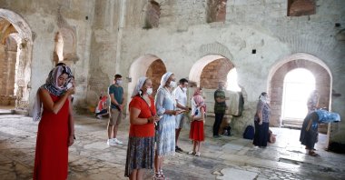 People wearing face masks against COVID-19 pray at an ancient church in Antalya, Turkey, July 14, 2020. (AA Photo) 