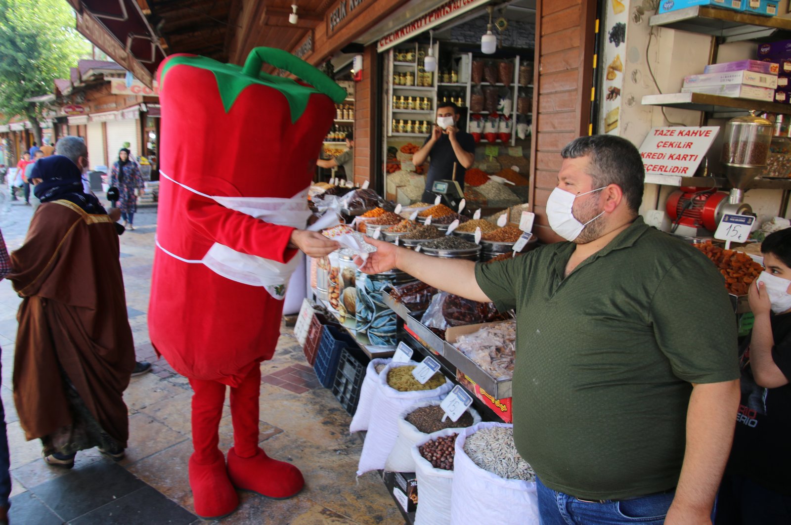 Dressed up as giant isot peppers, mascots distribute free masks to businesses and shop owners in Şanlıurfa, July 13, 2020. (AA Photo)