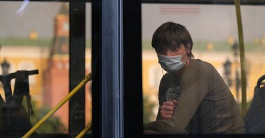 A passenger wearing a protective face mask as a preventive measure against COVID-19 looks through a bus window in Moscow, Russia, June 19, 2020. (REUTERS Photo)