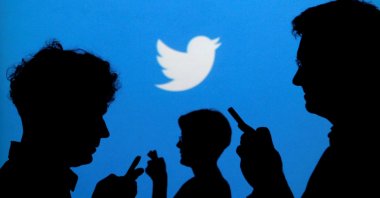 People holding mobile phones are silhouetted against a backdrop projected with the Twitter logo in this illustration picture taken in Warsaw, Poland, Sept. 27, 2013. (Reuters Photo)