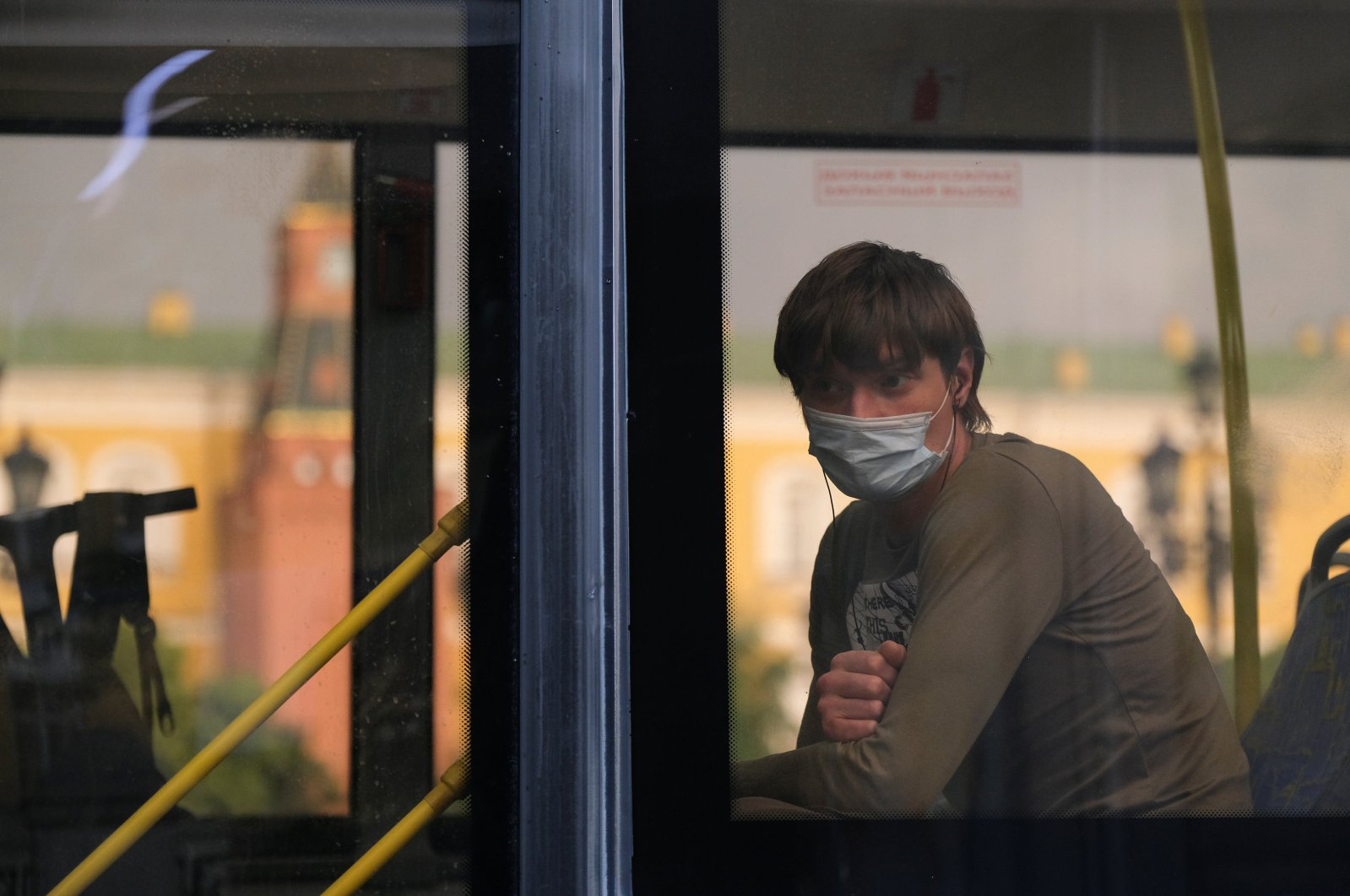 A passenger wearing a protective face mask as a preventive measure against COVID-19 looks through a bus window in Moscow, Russia, June 19, 2020. (REUTERS Photo)
