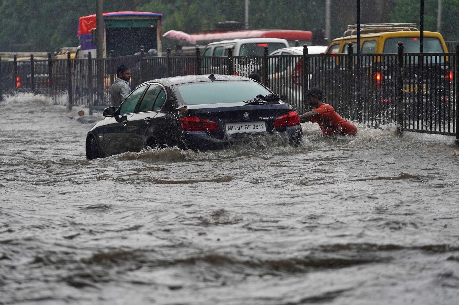A man pushes a car, stuck in a flooded road, during heavy rains in Mumbai, India, July 4, 2020. (Reuters Photo)
