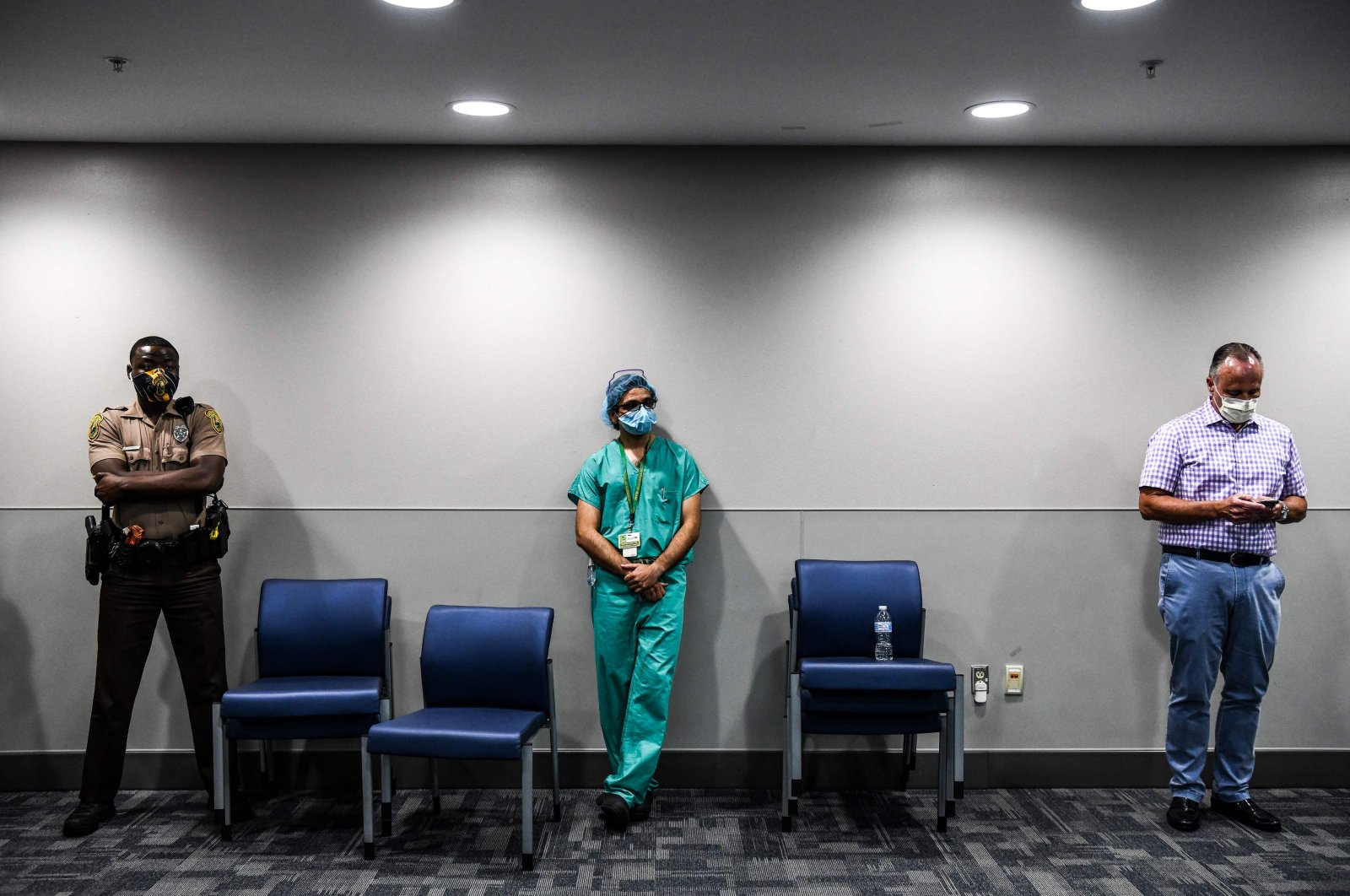 A doctor listens to the governor of Florida during a news conference at Jackson Memorial Hospital, Miami, Florida, U.S., July 13, 2020. (AFP Photo)