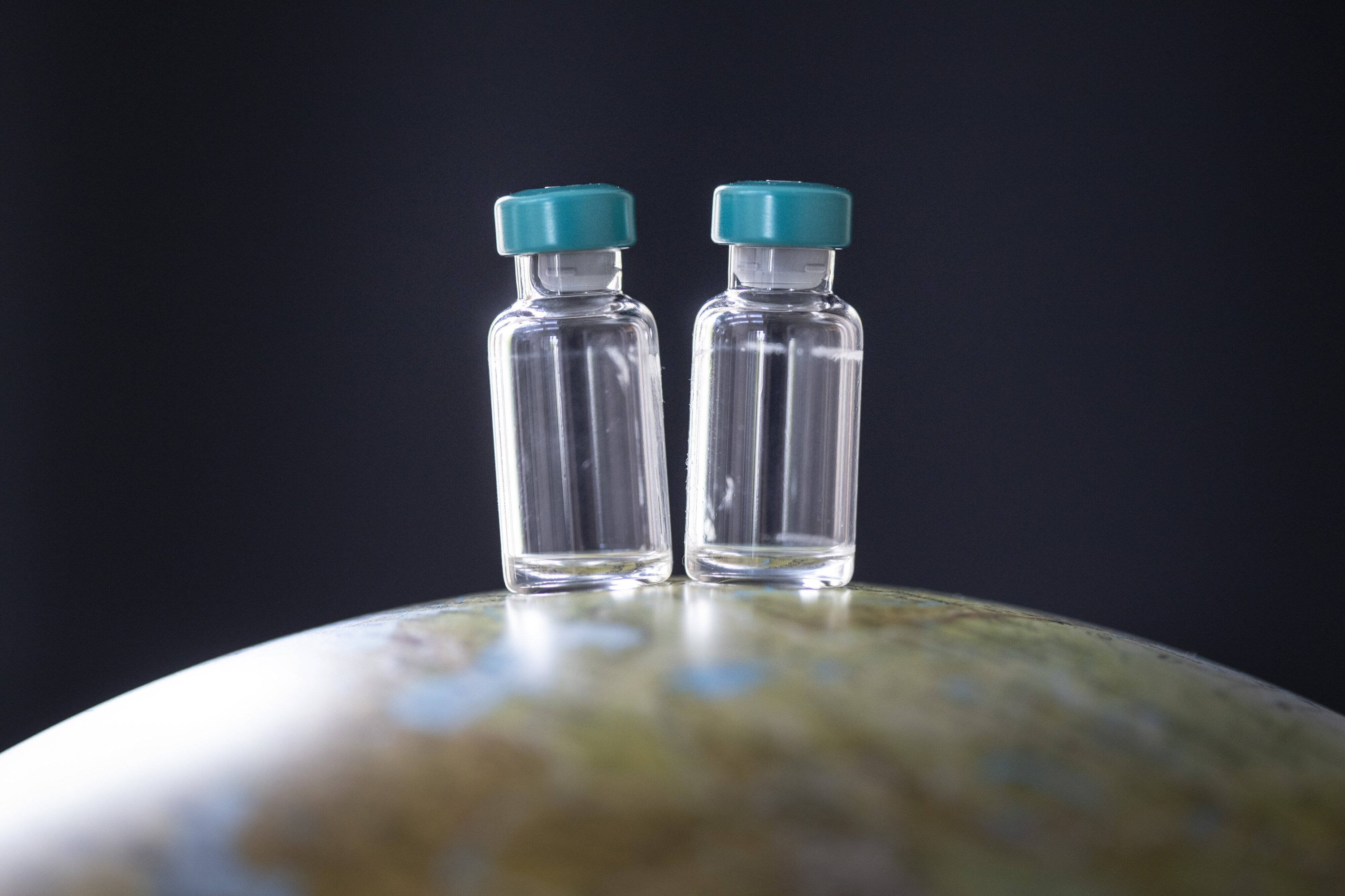 Two vaccine doses are seen on a globe in Bonn, Germany.(UtexGrabowsky/photothek.netx via Reuters)