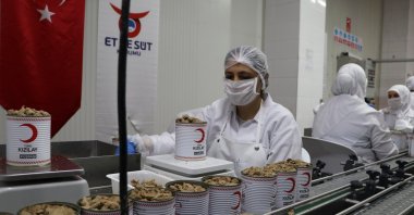 Workers fill cans bearing Turkish Red Crescent logo with meat, in Ankara, Turkey, July 17, 2020. (DHA Photo) 