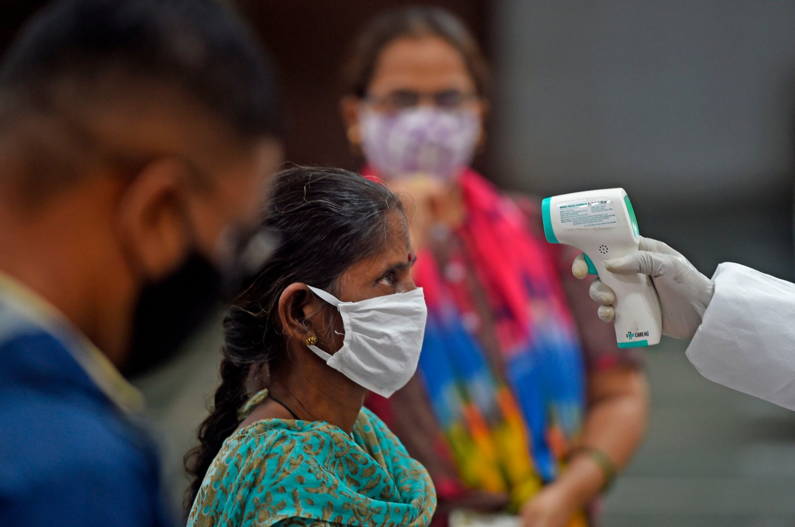 A medical volunteer takes a temperature reading of a woman at a marriage hall, Mumbai, India, July 17, 2020. (AFP Photo)