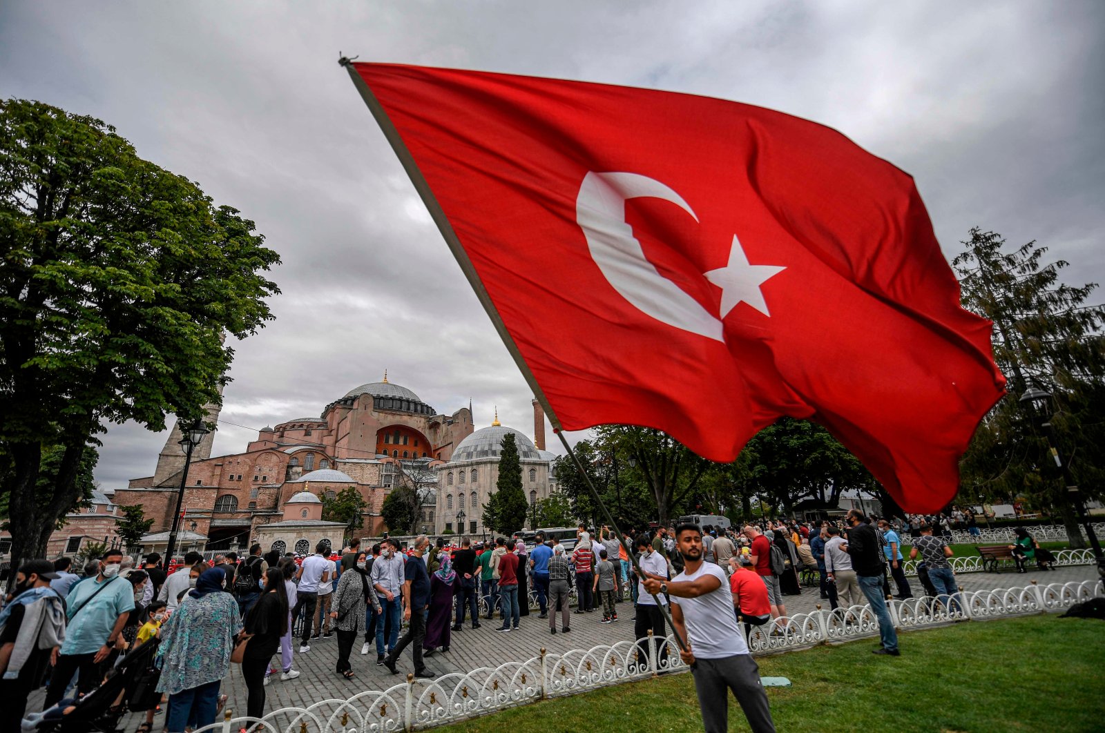 A man waves a Turkish national flag at Sultanahmet Square in front of Hagia Sophia during the fourth anniversary of the failed coup attempt in Istanbul, Turkey, July 15, 2020. (AFP)