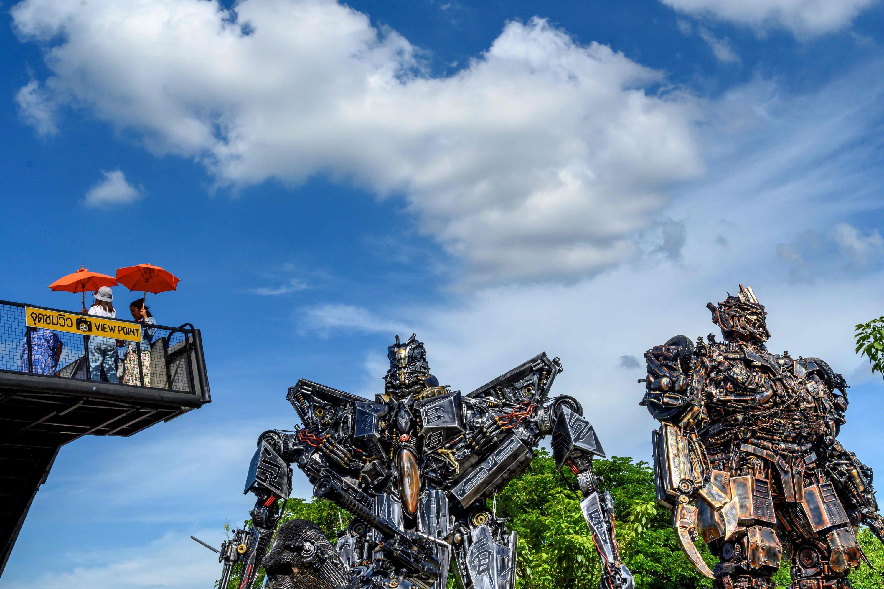 Tourists take photos of life-sized sculptures of characters from the "Transformers" film franchise made of scrap metal parts at the Ban Hun Lek museum in Ang Thong, Thailand, July 18, 2020. (AFP PHOTO)