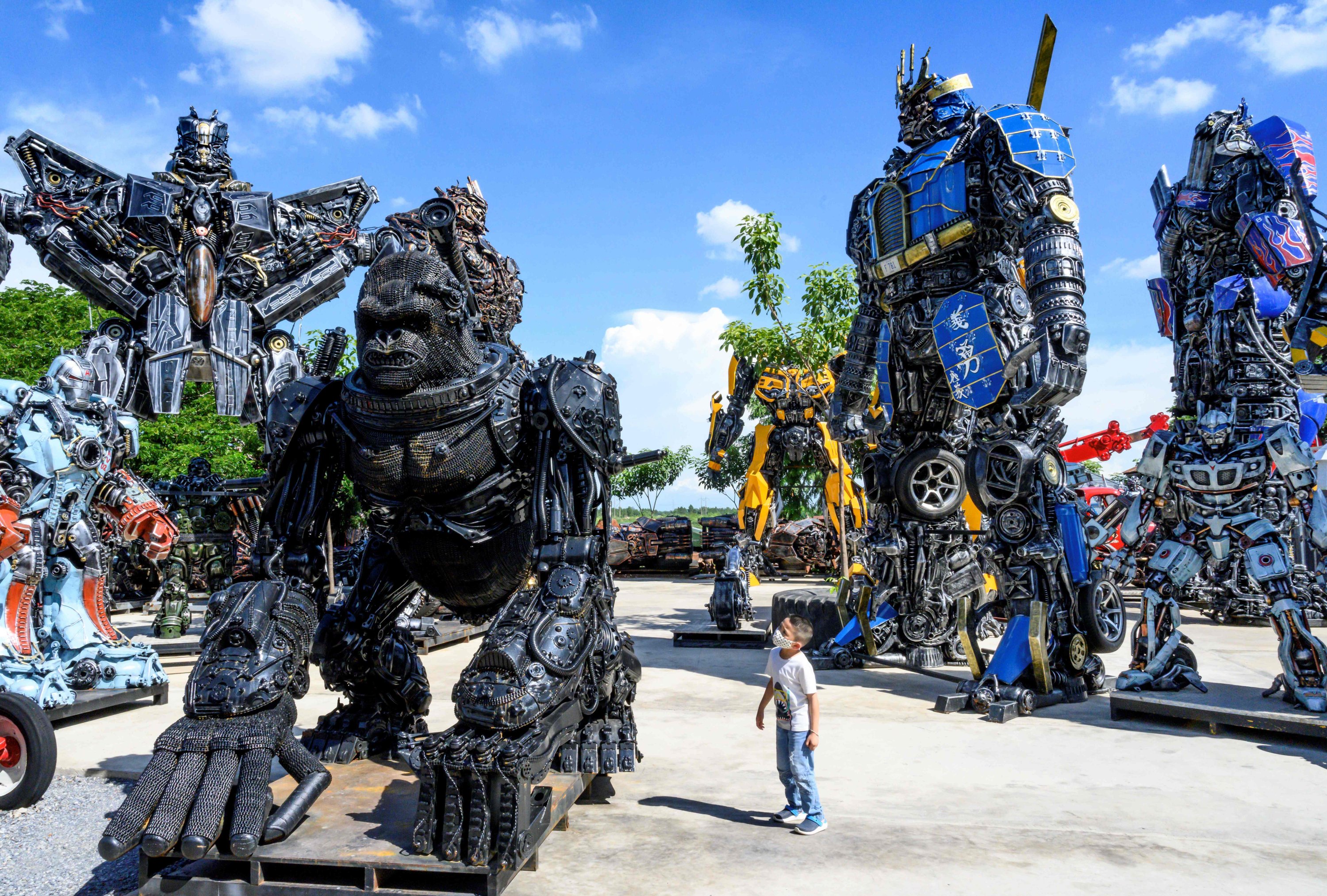 A child looks at a figure of King Kong in front of life-sized sculptures of characters from the "Transformers" film franchise, all made of scrap metal parts, at the Ban Hun Lek museum in Ang Thong, Thailand, July 18, 2020. (AFP PHOTO)