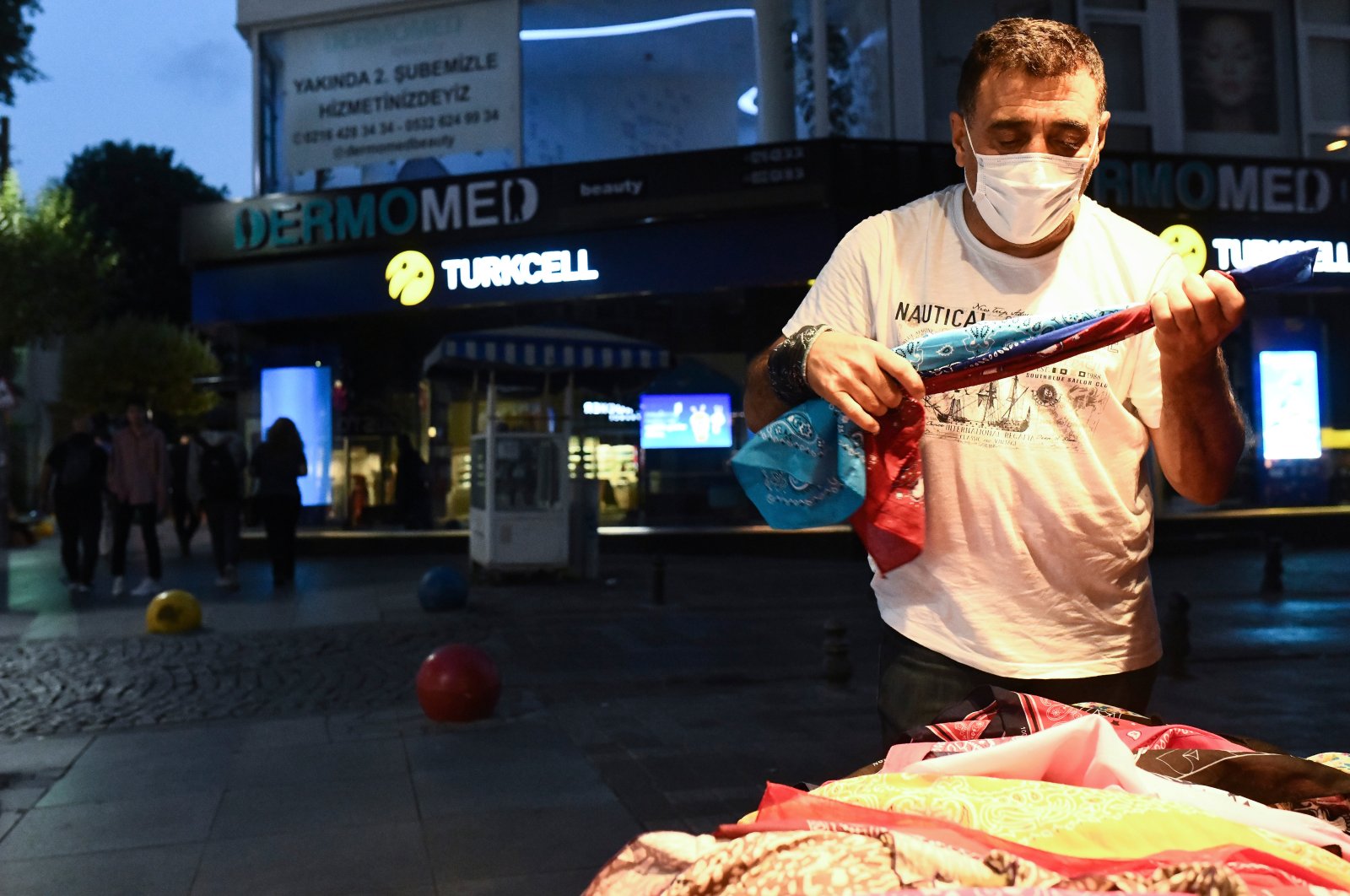 A vendor, wearing a face mask to prevent the spread of the coronavirus, stands outside his shop in Istanbul, Turkey, July 19, 2020. (AP Photo)