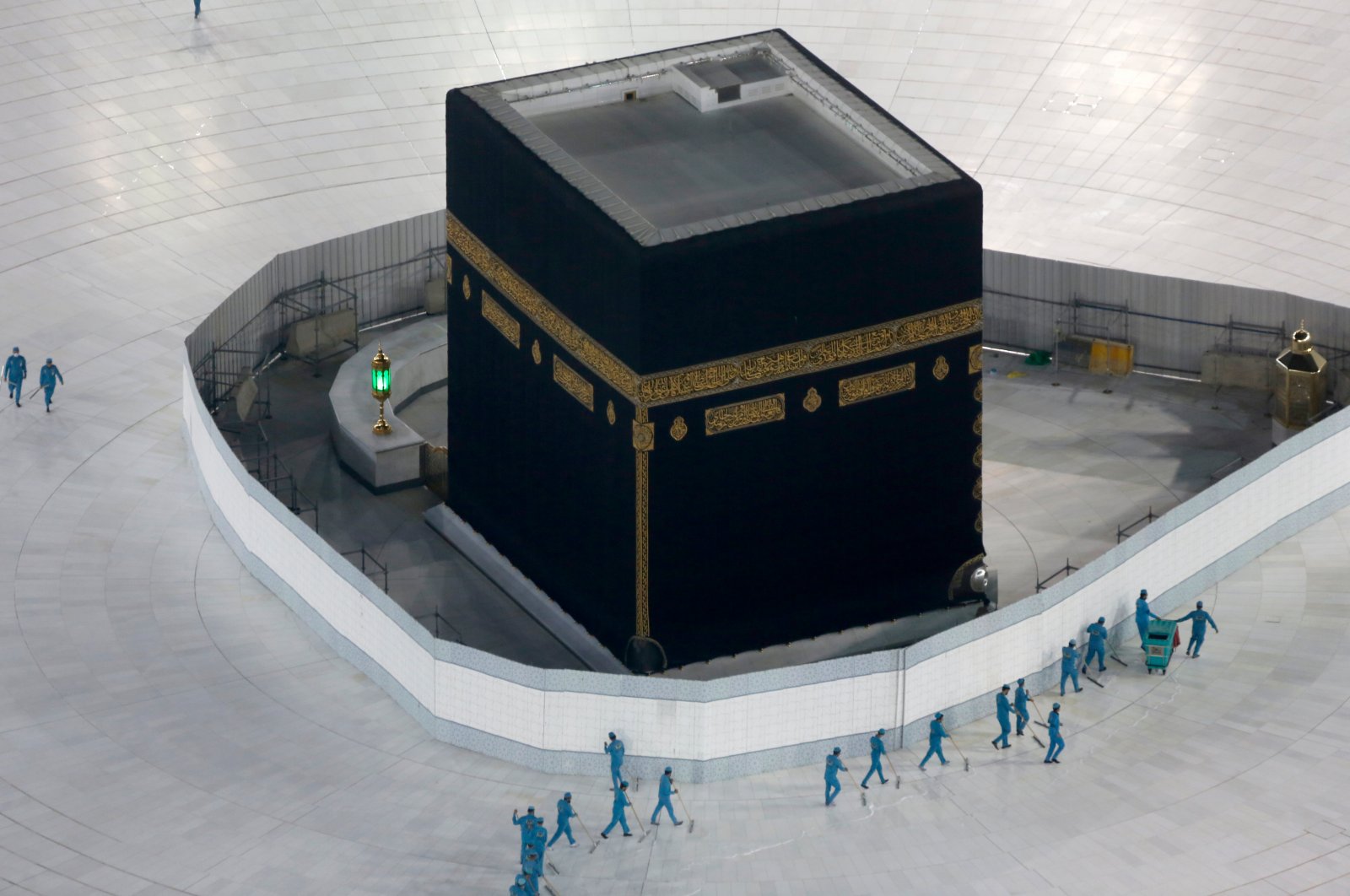 Workers disinfect the ground around the Kaaba, the cubic building at the Grand Mosque, over fears of the coronavirus, in the Muslim holy city of Mecca, Saudi Arabia, March 7, 2020. (AP Photo)