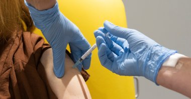In this handout photo released by the University of Oxford a volunteer participates in the vaccine trial in Oxford, England on July 7, 2020. (University of Oxford via AP)