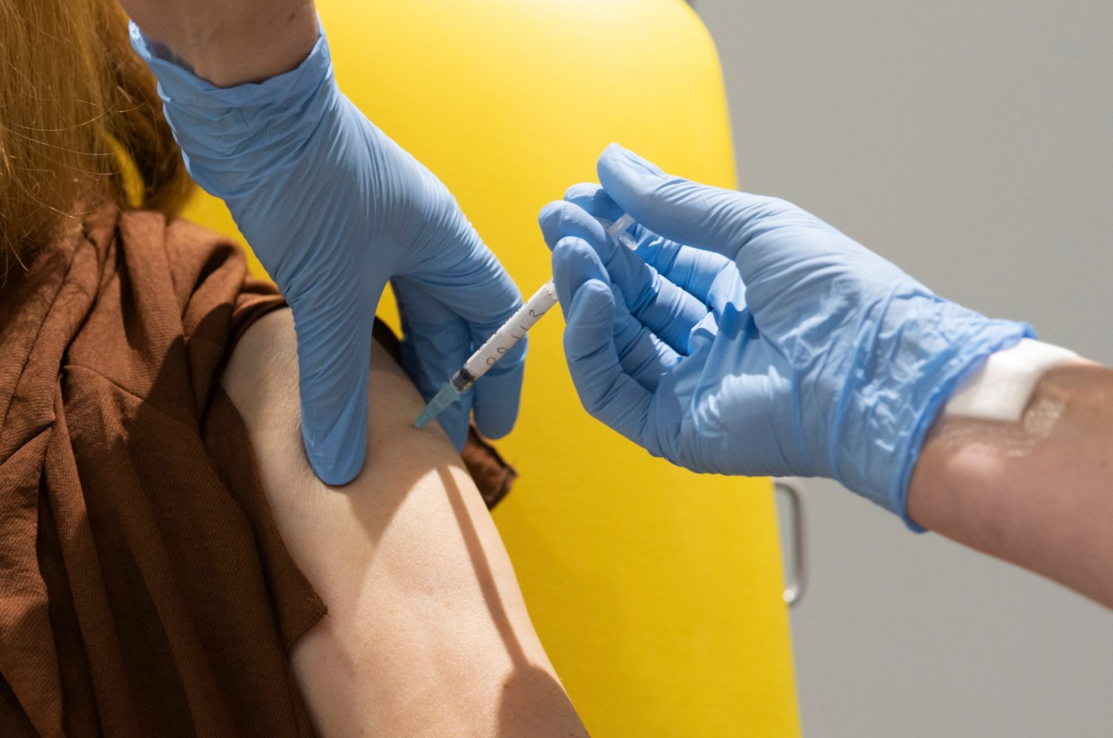 In this handout photo released by the University of Oxford a volunteer participates in the vaccine trial in Oxford, England on July 7, 2020. (University of Oxford via AP)