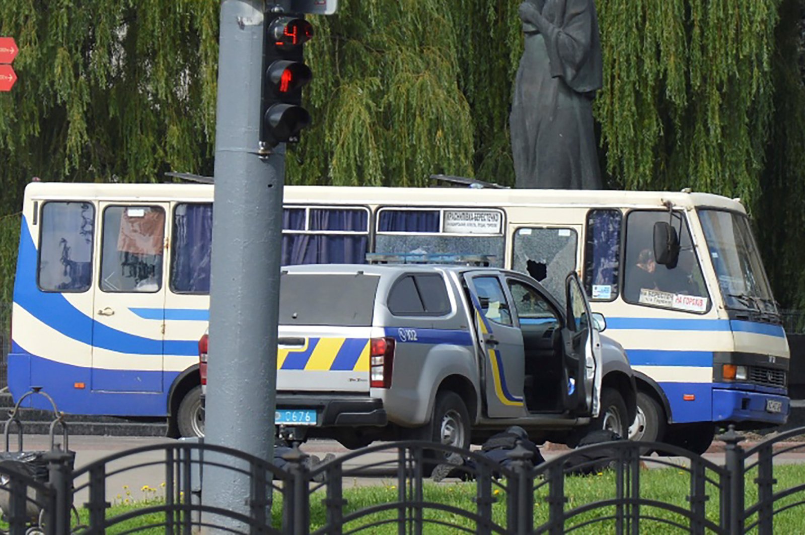Ukrainian law enforcement officers lie on the ground behind a car near a passenger bus, which was seized by an unidentified person in the city of Lutsk, Ukraine July 21, 2020. (Reuters Photo)