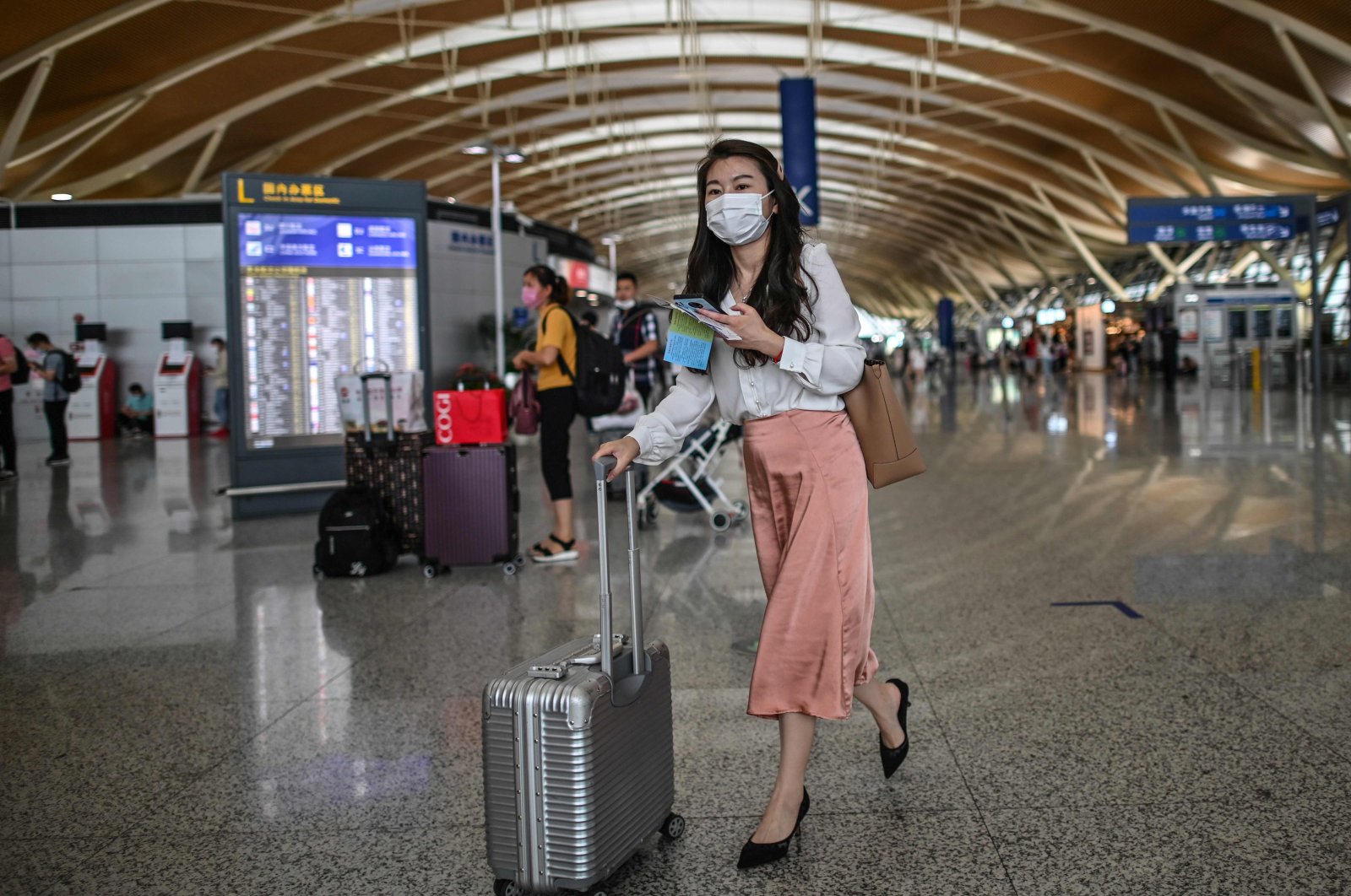 Passengers wearing face masks walk across a hall following preventive procedures against the spread of the coronavirus in Pudong International Airport in Shanghai, China, June 11, 2020. (AFP Photo)