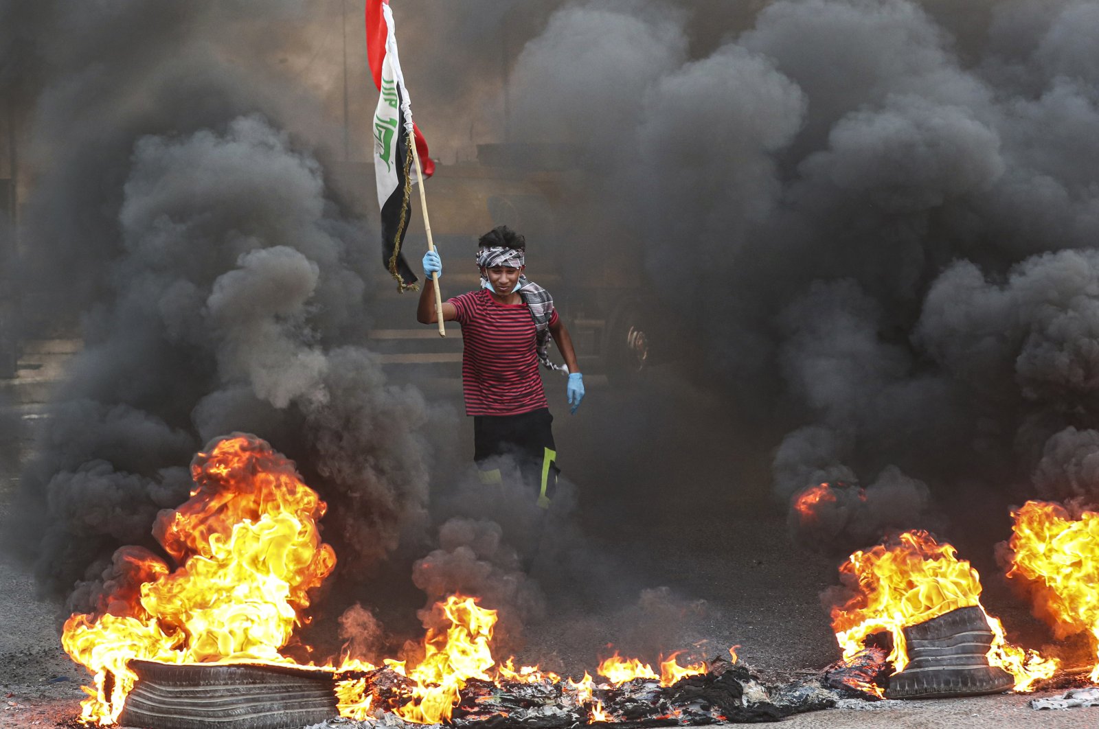 Protesters burn tires in front of the provincial council building during a demonstration where they demanded better public services, jobs and an end to corruption, Basra, southeast of Baghdad, Iraq, July 14, 2020. (AP Photo)