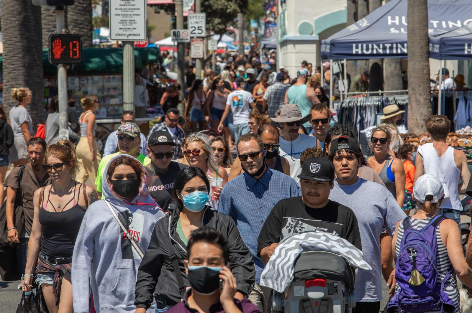 People cross the street in Huntington Beach, California, July 19, 2020. (AFP Photo)